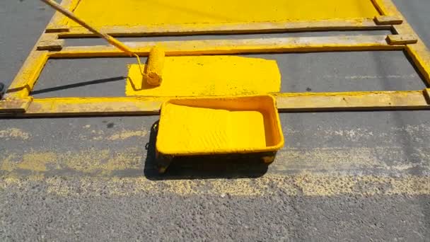 高速道路上の横断歩道の修理 従業員はローラーで道路上の黄色い線に塗り直します — ストック動画