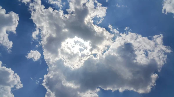 beautiful background of clouds, clearly visible lines of white clouds and blue sky, the top is the sunbeam, clouds like iron man, the concept of iron man