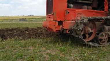 Bir çiftçi bir traktörün üzerinde tarla ekip toprağı gevşetiyor ve yabani otları yok ediyor, tarlayı ekime hazırlıyor. Oksijen zenginleştirmesi. 4k görüntü.