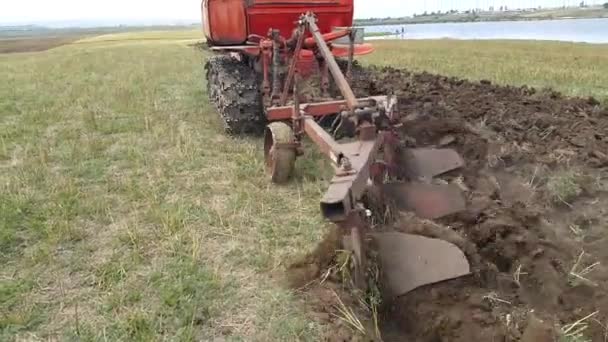農家はクローラートラクターのフィールドを栽培し 植え付けのためのフィールドを準備し 雑草と土壌を緩め 破壊します 酸素濃縮 4K映像 — ストック動画