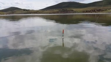 Suda yüzen bir balıkçı teknesi. Gölde dinlenme. Balık tutma kavramı. Balıkçılık malzemeleri. Hobiler ve eğlence.