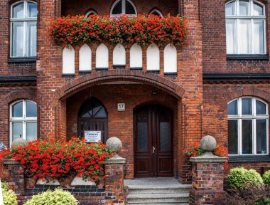 Çiçeklerle kırmızı tuğladan cephe 