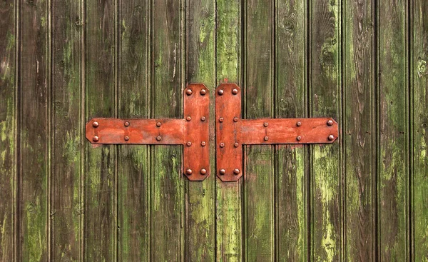 Elementi metallici su porta di legno verde incrinato — Foto Stock