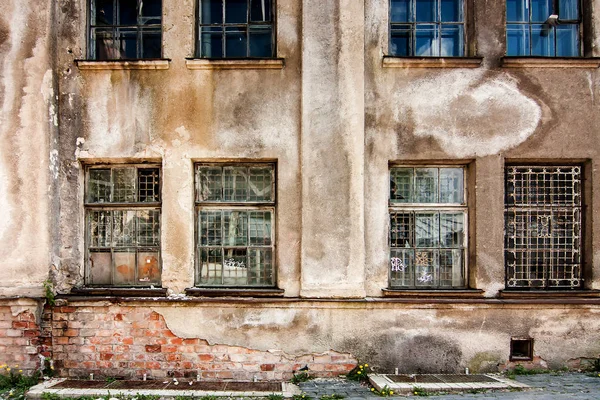 Стена с разбитыми окнами заброшенного здания — стоковое фото