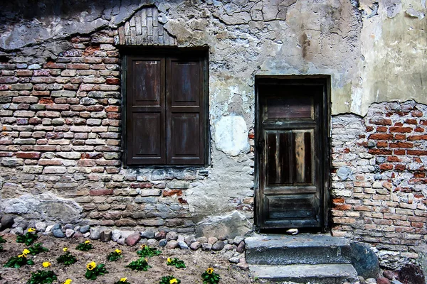 Oude muur van bakstenen met raam en deur — Stockfoto