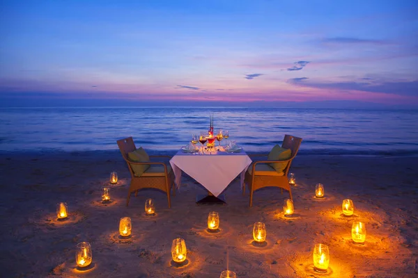 ワインを一杯 夕方にはサンセット トーン スタイル 夕日と海景とスカイラインの木製テーブルの上機器はロマンチックなキャンドル ライト ストックフォト