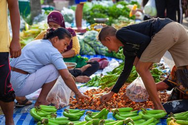 Krabi, Tayland 2 Nisan 202 'de sebze ve meyve satan kadın markette mangosteen hazırlıyor ve almak isteyen insanları bekliyor..