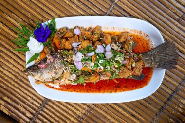 Taze bitkiden karışık salata ve acı biber, sarımsak, soğan gibi baharatlarla kaplı kızarmış levrekten yapılan Tayland yemekleri küçük parçalara ayrılır. Balık soslu ve limonlu mevsim.