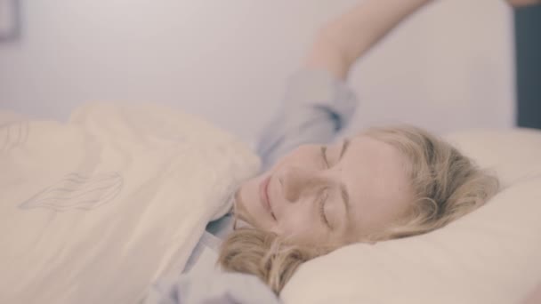 Γυναίκα Στο Κρεβάτι Ξυπνώντας Τέντωμα Και Χαμογελώντας Στην Κάμερα Αργή — Αρχείο Βίντεο