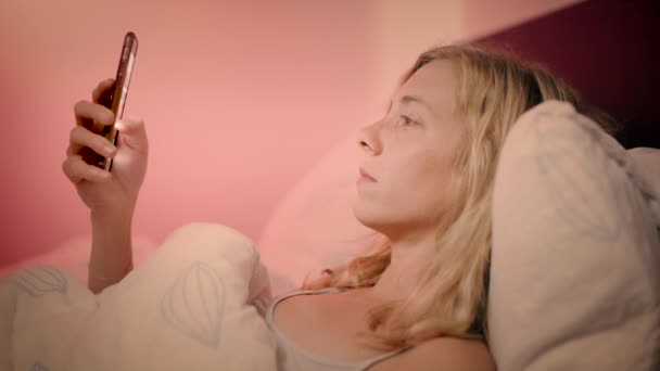 Kobieta Leżąca Łóżku Patrząc Jej Smartphone Nagle Wstrząśnięty Tym Patrzy — Wideo stockowe