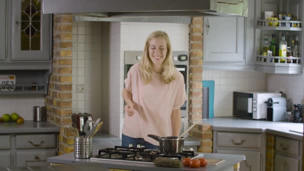 愚かなダンスをして食べ物を準備する台所で興奮した女性 — ストック動画