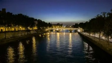 Paris Fransa'da şafak vakti hızlı geçen ve bir köprü altından geçen teknelerle kaplı Seine nehri güzel bir romantik görünümü zaman atlamalı