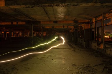 Gece eski terk edilmiş fabrika ve iki el feneri.
