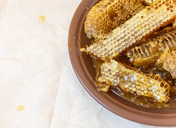 Medové plástve v hliněném plechu na papírovém pozadí. Přírodní organický včelí produkt. Zdravý životní styl. Zkopírujte místo pro text. Fotografie z blízka. — Stock fotografie