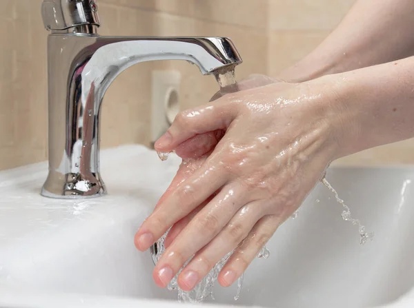 Hygiene. Cleaning Hands. Washing hands with clean water. Womans hand. Protect yourself from coronavirus COVID-19 pandemia. Close-up photo. — Stock Photo, Image