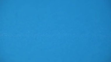 Renkli ataçlar mavi masaya düşer. Okul malzemeleri. ataçlar kapanıyor.