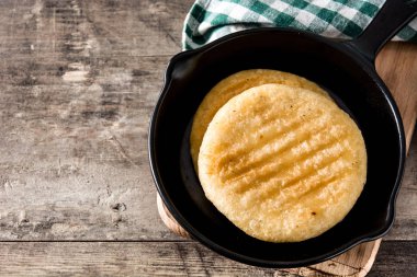 Arepas tavada ahşap masa. Venezuela geleneksel yemekler. Boşaltmak