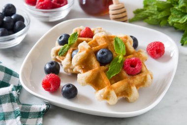 Yaban mersini ve ahududu beyaz mermer üzerinde geleneksel Belçika waffle