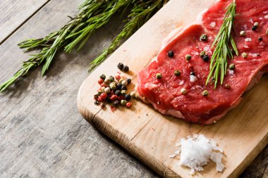 Ham sığır eti biftek ile baharatlı hazır ahşap masanın üzerine pişmiş olması. 