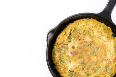 Yumurta ve beyaz arka plan üzerinde izole sebzeler demir tavada frittata yapmış. Boşaltmak
