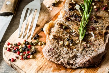 Izgara Dana biftek ve baharatlı rustik ahşap zemin üzerine