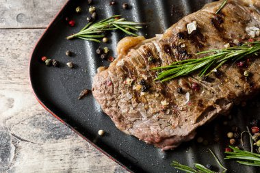 Izgara Dana biftek ve baharatlı rustik ahşap zemin üzerine