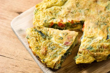Yumurta ve sebze ahşap masa üzerinde yapılan frittata.
