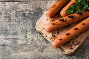 Ahşap masa üzerinde ızgara sosis. Üstten görünüm. Boşaltmak