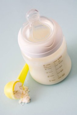 Biberon ve gri arka plan üzerinde süt. 