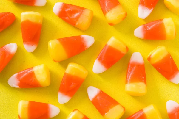 黄色の背景に典型的なハロウィーンのキャンディ コーン トップ ビュー — ストック写真