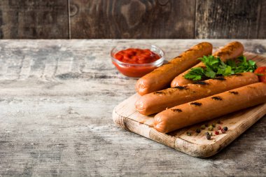 Izgara sosis ve ahşap masa ketçap. Boşaltmak