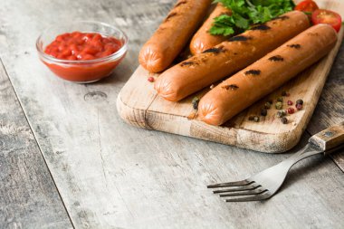 Izgara sosis ve ahşap masa ketçap. Boşaltmak