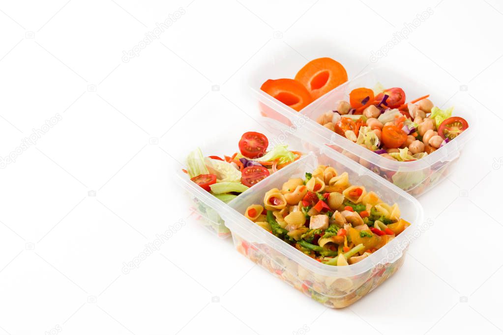 Healthy meal prep containers with pasta salad, vegetables, chickpea and fruit isolated on white background. Copyspace