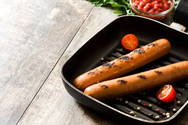 Izgara sosis tava ve ahşap masa ketçap