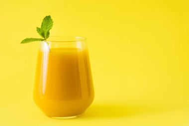 Mango Lassi tatlı. Sarı arka plan üzerinde geleneksel Hint içki. Boşaltmak