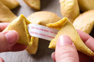 Kağıt ahşap masa üzerinde iletide fal kurabiyesi açılarak el