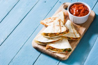 Mexican quesadilla tavuk, peynir ve biber mavi ahşap masa üzerinde. Boşaltmak