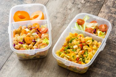 Beslenme çantası ile sağlıklı gıda ahşap masada yemek hazır. 