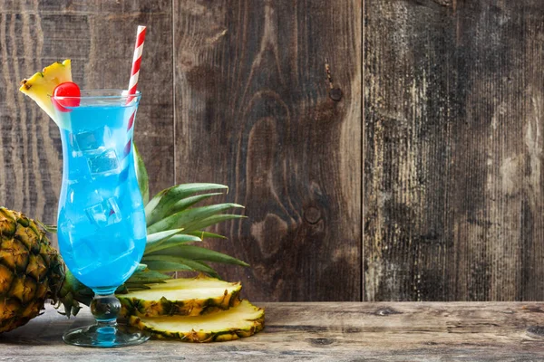 Blue Hawaiian cocktail on wooden table. Copyspace