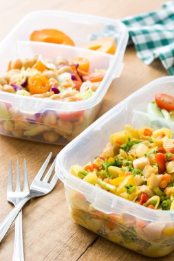 Sağlıklı yemek hazırlık kapları ile yemek yemeye hazır. Ahşap masa üzerinde makarna salatası. Boşaltmak