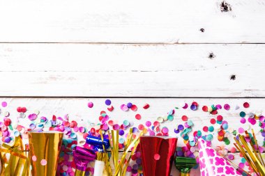 Parti arka plan. Parti kapaklar ve konfeti Beyaz ahşap zemin üzerinde. Üstten görünüm. Boşaltmak