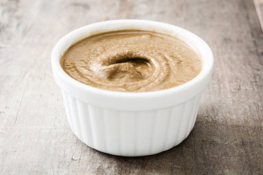 Tahin daldırma ahşap masa üzerinde beyaz kase. Yakın çekim