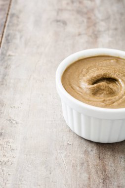 Tahin daldırma ahşap masa üzerinde beyaz kase. Yakın çekim