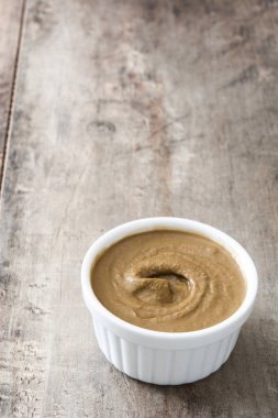 Tahin daldırma ahşap masa üzerinde beyaz kase. Yakın çekim