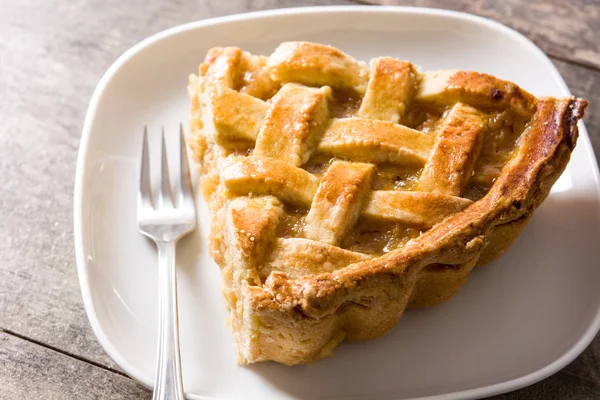 Homemade apple pie slice on wooden table