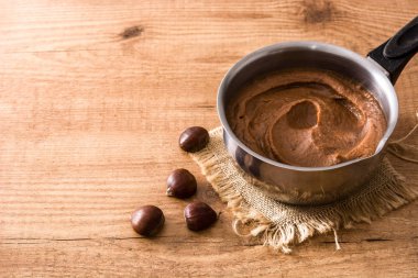 Kestane pot ahşap masa üzerinde krem. Boşaltmak