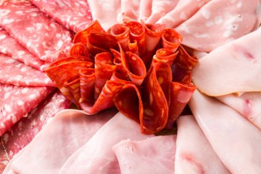 Soğuk et kesme tahtası üzerinde yakın çekim. Jambon, salam, sosis mortadella ve Türkiye