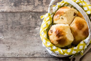 Geleneksel Paskalya hot cross buns ahşap masa üzerinde bir sepet. Boşaltmak