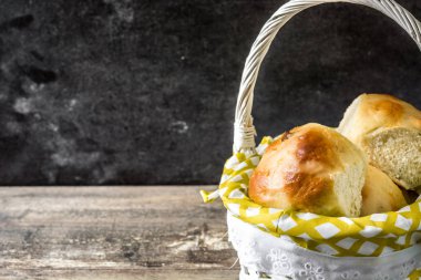 Geleneksel Paskalya hot cross buns ahşap masa üzerinde bir sepet. Boşaltmak