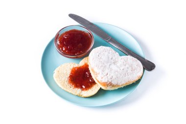 Beyaz arka plan üzerinde izole kalp şeklindeki çörek ve böğürtlen reçeli ile romantik kahvaltı. 